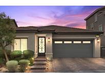 Charming single-story home showcasing a well-manicured yard and a two-car garage with brick driveway at 3 Vicolo Sebino, Henderson, NV 89011