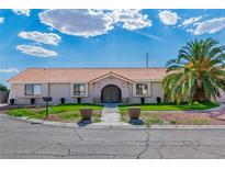 Charming single-story home with a well-manicured lawn and mature palm tree providing curb appeal at 465 E Robindale Rd, Las Vegas, NV 89123