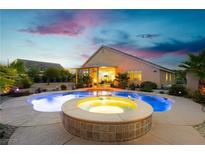 Inviting backyard pool and spa featuring lush landscaping, an outdoor seating area, and a beautiful sunset sky at 6617 Golden Bit Ave, Las Vegas, NV 89131