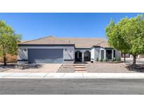 Charming single-story home featuring desert landscaping, a two-car garage, and a welcoming entrance at 9100 Shelter Cove Ct, Las Vegas, NV 89117