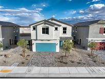 Charming two-story home with a blue garage door and desert landscaping at 1289 Miller Springs Ln # 96, North Las Vegas, NV 89084