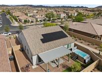 Aerial view of backyard with a hot tub, covered patio, and solar panels on the roof at 605 Cadence Vista Dr, Henderson, NV 89011
