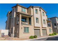 Beautiful stucco townhome features a balcony, manicured landscaping, and an attached garage at 6953 Midnight Bronze St, North Las Vegas, NV 89086