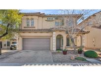 Beautiful two-story home with a neutral color palette, arched entry, brick driveway, and attached two-car garage at 8139 Skytop Ledge Ave, Las Vegas, NV 89178