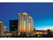 Stunning exterior view of a high-rise building with illuminated accents against a vibrant night sky at 135 E Harmon Ave # 2702, Las Vegas, NV 89109