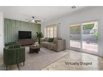 Bright living room with stylish decor, neutral tones, and sliding door access to the backyard at 2149 Kelsey Creek Ct, Henderson, NV 89044