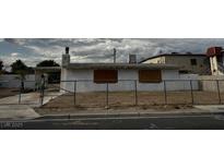 Exterior shot of a single-story home behind a chain link fence on an overcast day at 2645 Cedar Ave, Las Vegas, NV 89101
