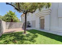 Inviting front yard with green grass, decorative brick, shade tree, and stylish stucco exterior with arched doorway at 278 Star Cluster Cir, Las Vegas, NV 89145