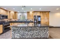 Spacious kitchen featuring custom wood cabinetry, stainless steel appliances, and a large mosaic-tiled island at 3557 Wayne Cir, Las Vegas, NV 89121
