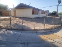 Shows the front exterior of the home with beige walls and a chain link fence at 4430 Judson Ave, Las Vegas, NV 89115
