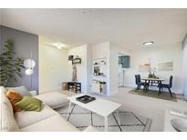 Bright living room featuring modern decor, light floors, and an open layout to the dining area at 4683 Monterey Cir # 4, Las Vegas, NV 89169
