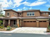 Two-story home with a three-car garage, desert landscaping, and a red-tiled roof at 585 Via Alhambra, Las Vegas, NV 89123