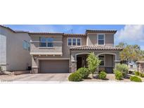 Two-story home with a two-car garage, landscaped front yard and covered porch with stone accents at 6370 Ava Ridge Ave, Las Vegas, NV 89141