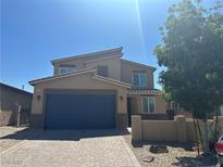 Two-story home featuring a paver driveway, a two-car garage and a modern design at 7636 Bandon Cliffs St, North Las Vegas, NV 89084