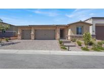 Charming home showcasing a three-car garage and well-maintained front yard with lush landscaping and beautiful hardscape at 10904 Ellis Pointe Ave, Las Vegas, NV 89166