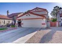 Charming home featuring a two-car garage, tile roof, desert landscaping, and a private courtyard entrance at 117 Lotus Blossom Ct, Las Vegas, NV 89145