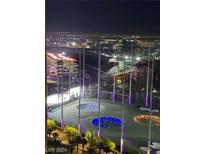 Night view of Topgolf with city lights in the background, showcasing nearby entertainment at 135 E Harmon Ave # 2116, Las Vegas, NV 89109