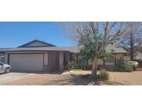 Charming single-story home featuring a two-car garage, mature tree, and desert landscaping at 1886 Ludington Ave, Las Vegas, NV 89156