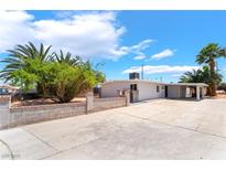 Charming single-story home featuring a spacious driveway and desert landscaping with multiple palm trees at 2749 Del Mar Pl, Las Vegas, NV 89169