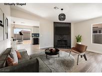 Inviting living room with modern furnishings, fireplace with stylish black tile and wood-look flooring at 5004 Celebrity Cir, Las Vegas, NV 89119
