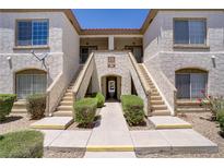 Inviting condo exterior with stucco, stairs, and lush landscaping at 5112 Harvest Time St # 201, Las Vegas, NV 89130