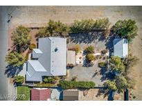 An aerial view of the property showcases the house, guest house, trees, landscaping, and surrounding desert terrain at 5981 Doubletree Rd, Pahrump, NV 89061