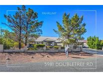Charming Pahrump home with well-kept landscaping and a decorative brick fence at 5981 Doubletree Rd, Pahrump, NV 89061