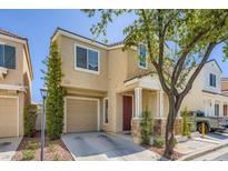 Inviting two-story home with a well-maintained lawn and a cozy front porch with stone accents at 6125 Broken Slate Way, Las Vegas, NV 89139