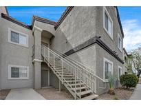 Condo exterior with stucco, gray paint, tile roof, staircase, and desert landscaping at 6160 Rumrill St # 202, Las Vegas, NV 89113