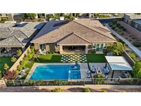 Stunning aerial view of backyard featuring a pool, spa, covered patio, lounge area, and lush landscaping at 9972 Terrastone Dr, Las Vegas, NV 89148