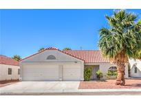 Charming single-story home featuring a two-car garage and a tile roof, surrounded by low-maintenance landscaping at 2109 Mountain Sunset Ave, North Las Vegas, NV 89031