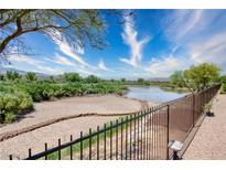 Scenic backyard view with desert landscaping and a pond, creating a tranquil outdoor space at 693 Hagens Aly, Mesquite, NV 89027