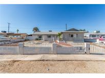 Single story home featuring a desert landscape with cinderblock and wrought iron fence in front at 1108 Princess Katy Ave, Las Vegas, NV 89119