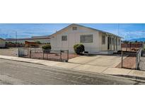 Charming single-story home featuring a paved driveway and minimalist landscaping, fenced for added privacy at 1608 June Ave, North Las Vegas, NV 89032