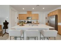 Bright kitchen featuring an island with barstool seating and stainless steel appliances at 2261 Cold Canyon Ave, North Las Vegas, NV 89086