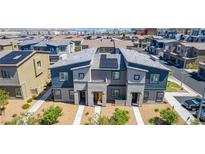 Two-story townhome with gray and blue exterior paint, solar panels, and small front yard landscaping at 527 Clearsable Ave, Henderson, NV 89044
