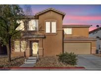 Two-story home featuring a charming front entrance, two-car garage, and low-maintenance desert landscaping at 5308 Carlsbad Heights St, North Las Vegas, NV 89081