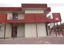 Exterior view of building featuring access stairs, upper balcony, neutral paint, and red accent trim at 5388 Swenson St # 26, Las Vegas, NV 89119