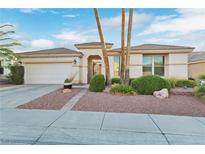 Charming single-story home with desert landscaping, mature palm trees and attached two-car garage at 585 Mountain Links Dr, Henderson, NV 89012