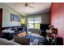 Inviting living room featuring a dark leather couch, area rug, and an abundance of natural light at 7255 W Sunset Rd # 2030, Las Vegas, NV 89113