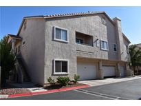 Multi-level condo building with garage parking and second-story entrances and neutral stucco finish at 7450 S Eastern Ave # 1012, Las Vegas, NV 89123