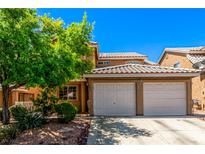Charming home featuring a two-car garage, well-maintained landscaping, and a classic tile roof at 8041 Astrology Ct # 201, Las Vegas, NV 89128