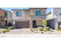 Beautiful two-story home featuring a two-car garage, stone accents, and manicured landscaping at 9256 Alden Pointe Ct, Las Vegas, NV 89143