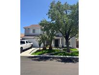 Charming two-story home featuring a spacious garage, well-maintained lawn, and mature trees for shade at 9511 Teton Vista Ave, Las Vegas, NV 89117