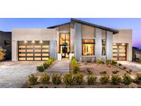 Stunning modern home featuring a landscaped front yard, two car garage, and unique architectural details at 10848 Vista Altura Ave, Las Vegas, NV 89135