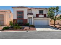 Two-story home featuring a red tiled roof, brick accents, and a two-car garage at 10952 Porto Foxi St, Las Vegas, NV 89141