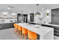 Bright, modern kitchen featuring a large island with seating and sleek, dark cabinetry at 3189 Montecito Dr, Las Vegas, NV 89120