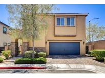 Inviting two-story home featuring a blue garage door, stone accents, and well-manicured landscaping at 6897 Linda Creek Ct, Las Vegas, NV 89178