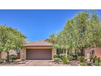 Charming single-story home featuring a terra cotta roof, desert landscaping, and a two-car garage at 7998 Base Camp Ave, Las Vegas, NV 89178