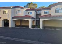 Multi-level condo building with terracotta tile roof, covered parking, and landscaped entrance at 8455 W Sahara Ave # 258, Las Vegas, NV 89117